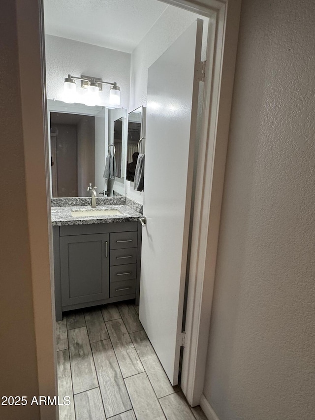 8101 N 107th Ave Unit 26, Peoria, AZ 85345 - bathroom featuring a textured wall, vanity, and wood tiled floors