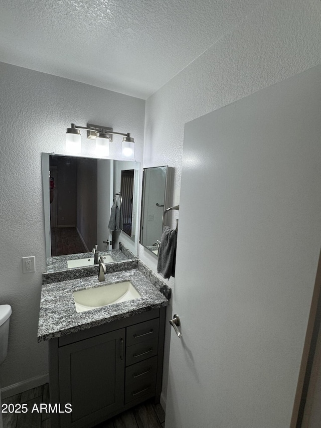 8101 N 107th Ave Unit 26, Peoria, AZ 85345 - half bathroom featuring a textured ceiling, toilet, vanity, and a textured wall