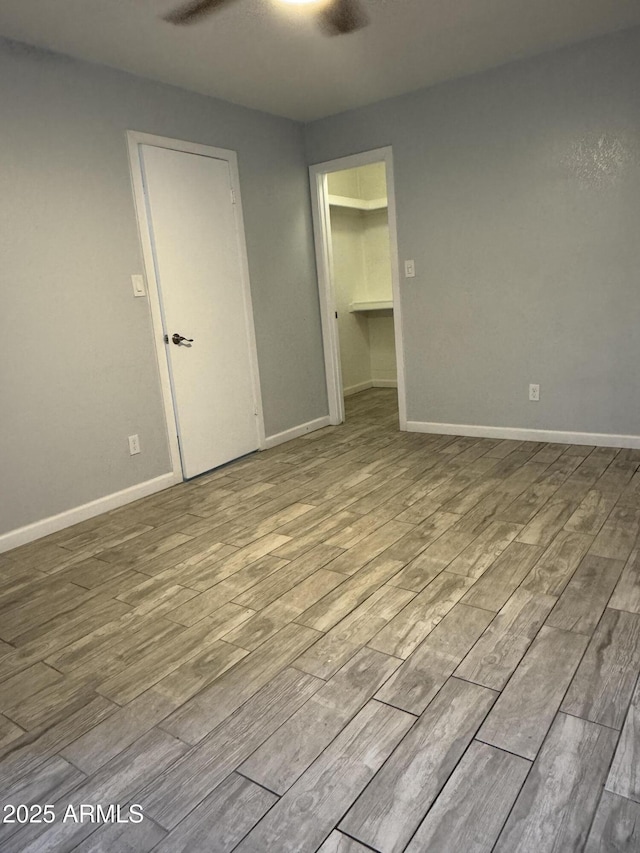 8101 N 107th Ave Unit 26, Peoria, AZ 85345 - unfurnished bedroom with wood finished floors, baseboards, and a walk in closet