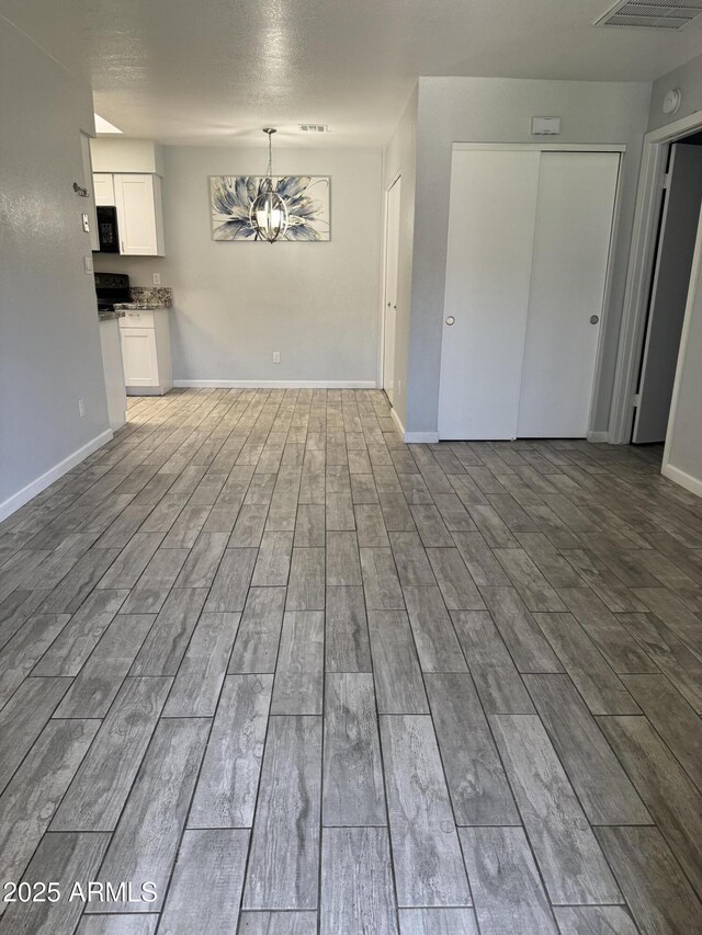 8101 N 107th Ave Unit 26, Peoria, AZ 85345 - unfurnished living room with a chandelier, wood finished floors, and baseboards