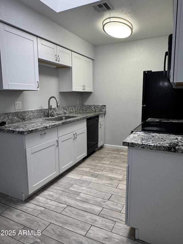 8101 N 107th Ave Unit 26, Peoria, AZ 85345 - kitchen featuring black appliances, a sink, light wood-type flooring, white cabinets, and baseboards