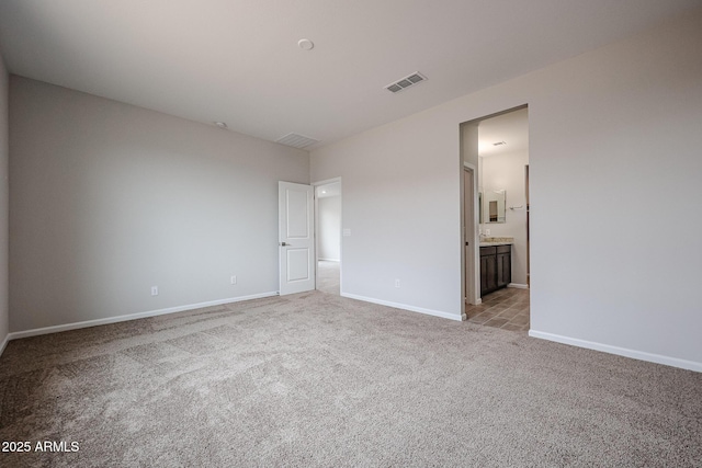 1917 S 246th Ln, Buckeye, AZ 85326 - unfurnished bedroom with baseboards, ensuite bathroom, visible vents, and light colored carpet