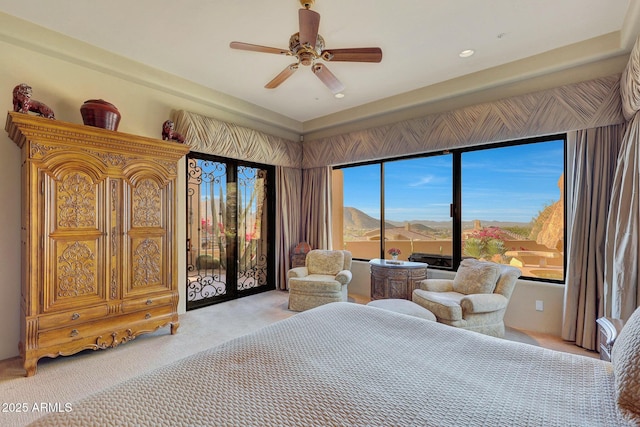 bedroom with ceiling fan, access to exterior, a mountain view, and light carpet