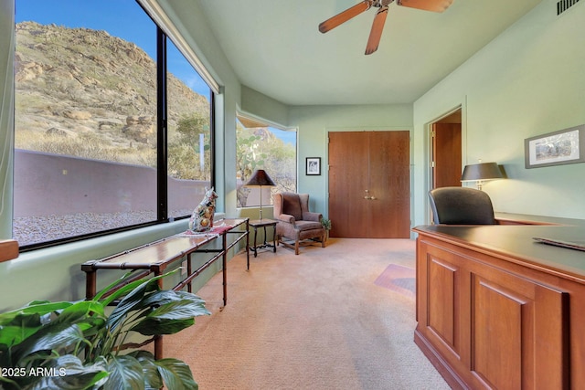 carpeted office space featuring ceiling fan