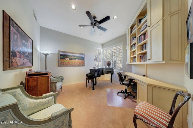 carpeted home office featuring ceiling fan