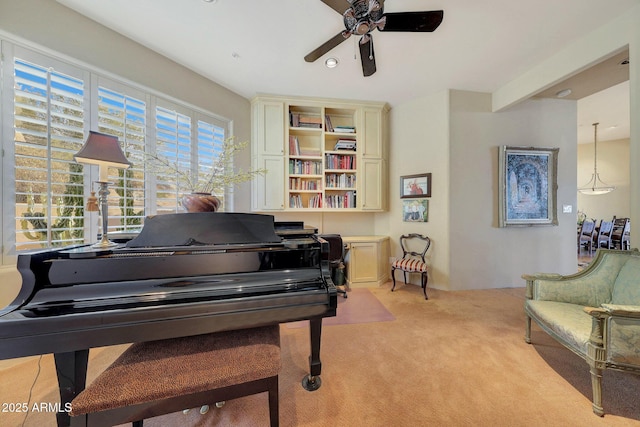 sitting room featuring ceiling fan and light colored carpet