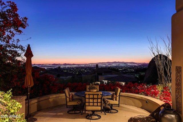 patio terrace at dusk featuring a mountain view