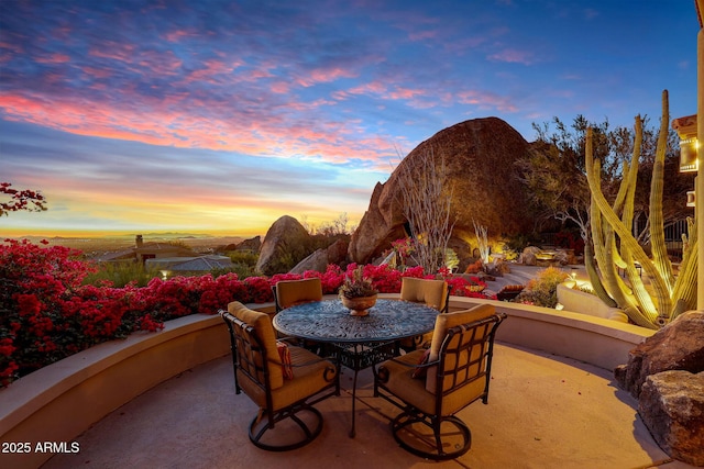 patio terrace at dusk featuring a mountain view