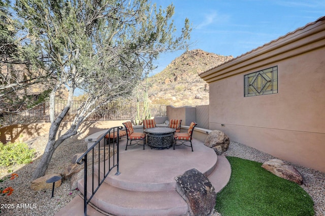 view of patio with a fire pit and a mountain view