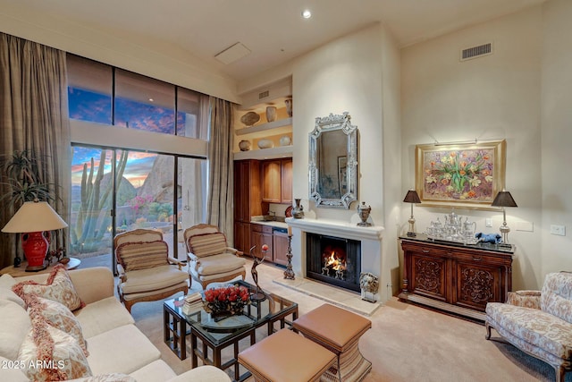 carpeted living room with built in shelves and a large fireplace