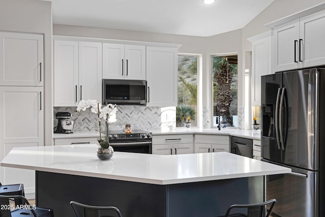 kitchen with stainless steel appliances, a kitchen island, and a breakfast bar