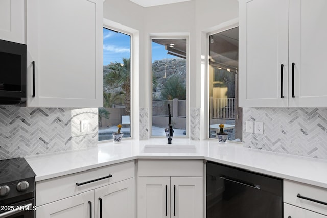 kitchen featuring white cabinetry, backsplash, and black appliances