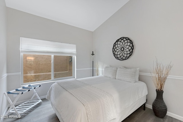 bedroom with hardwood / wood-style floors and vaulted ceiling