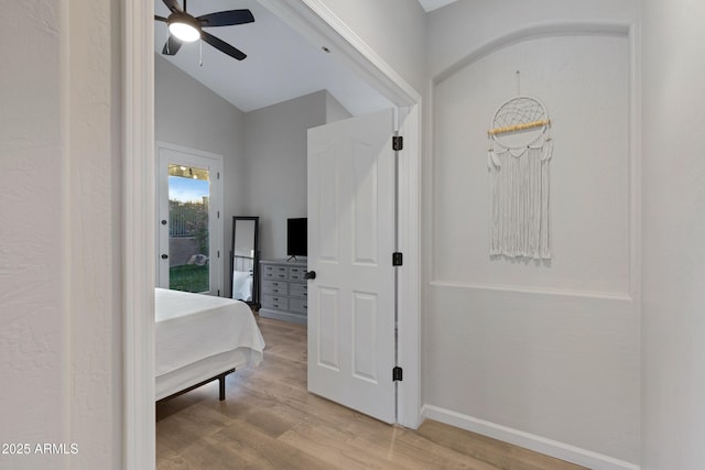 hallway with lofted ceiling and light wood-type flooring