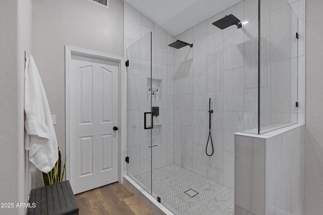 bathroom featuring an enclosed shower and wood-type flooring