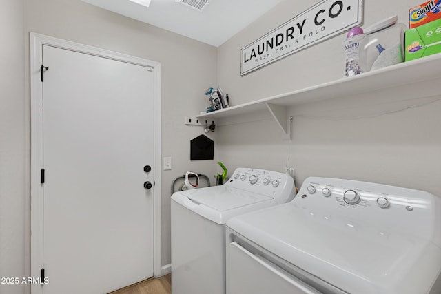 laundry room featuring washer and clothes dryer and light hardwood / wood-style floors