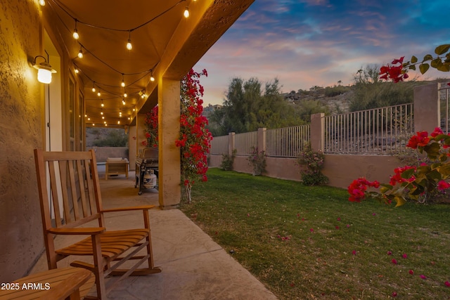 yard at dusk featuring a patio area