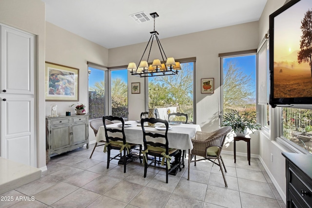 tiled dining room featuring an inviting chandelier and a wealth of natural light