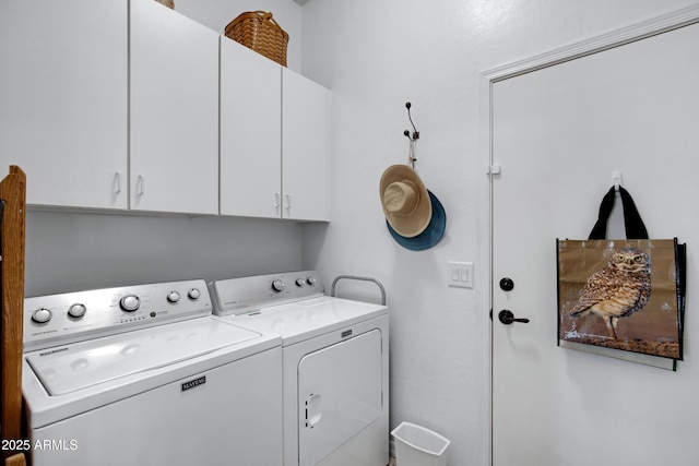 clothes washing area with washer and clothes dryer and cabinets