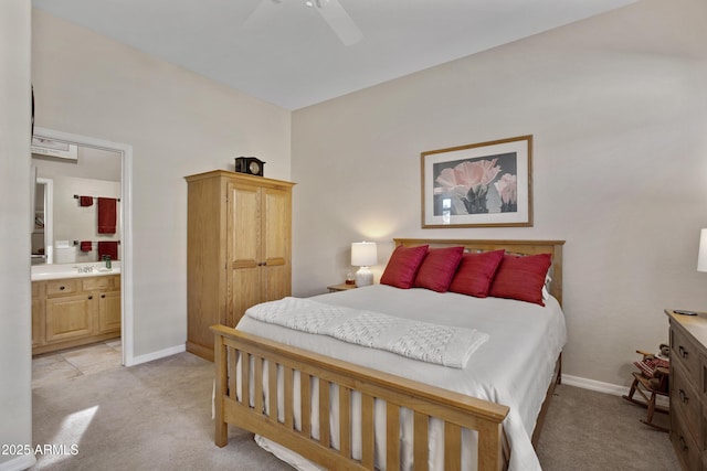 carpeted bedroom featuring ceiling fan and ensuite bath