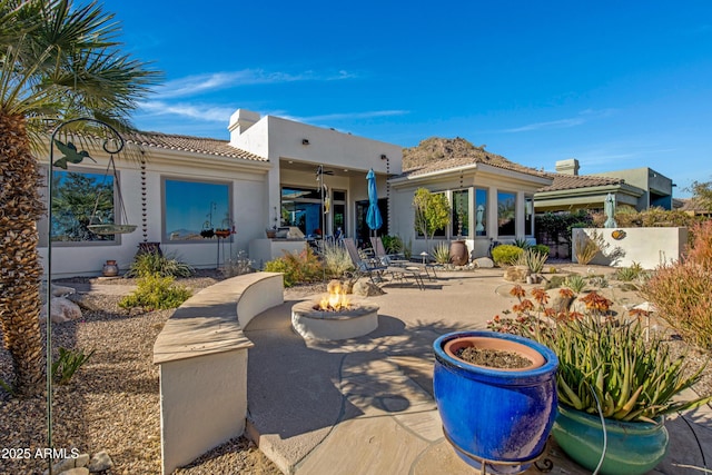 back of property featuring a fire pit and a patio area