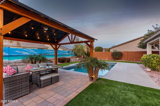 pool at dusk with a fenced in pool, a patio, a gazebo, a fenced backyard, and an outdoor living space