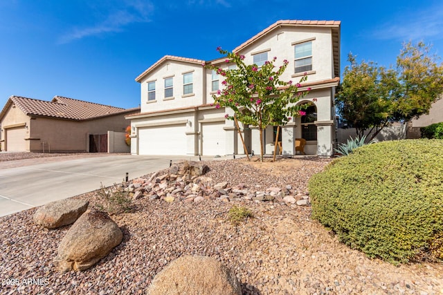 view of front facade with concrete driveway, an attached garage, and stucco siding