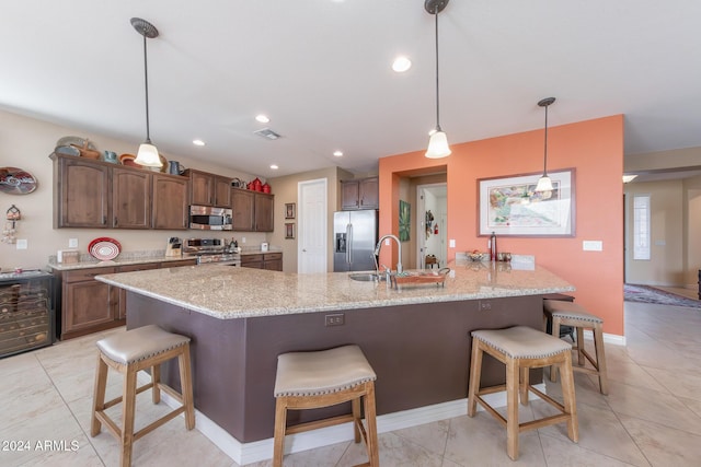 kitchen with sink, decorative light fixtures, a breakfast bar area, and appliances with stainless steel finishes