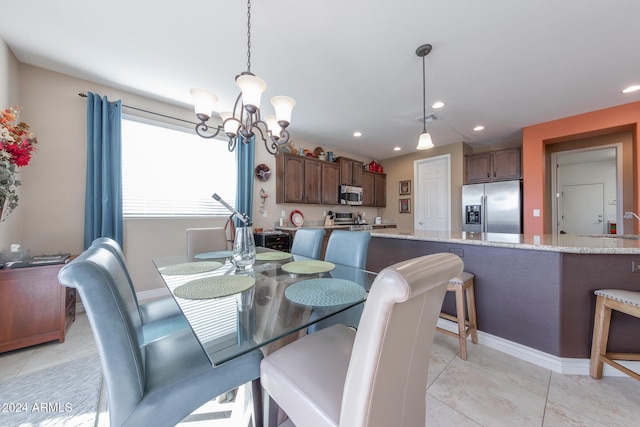 tiled dining room with sink and a notable chandelier