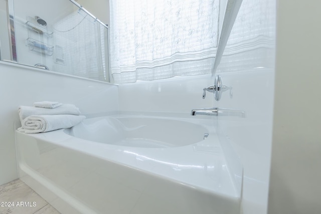 bathroom with tile patterned flooring and a tub to relax in