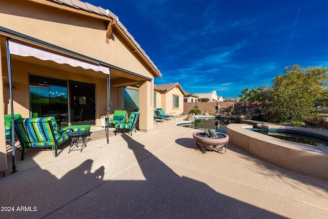 view of patio featuring a swimming pool with hot tub