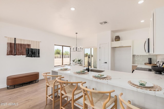 4561 E Red Bird Ln, San Tan Valley, AZ 85140 - kitchen with a peninsula, stove, white cabinets, recessed lighting, and decorative backsplash