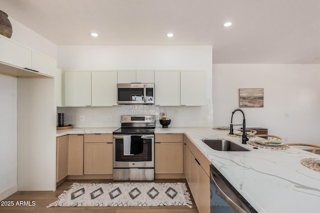 4561 E Red Bird Ln, San Tan Valley, AZ 85140 - kitchen with appliances with stainless steel finishes, light stone countertops, light wood finished floors, tasteful backsplash, and recessed lighting