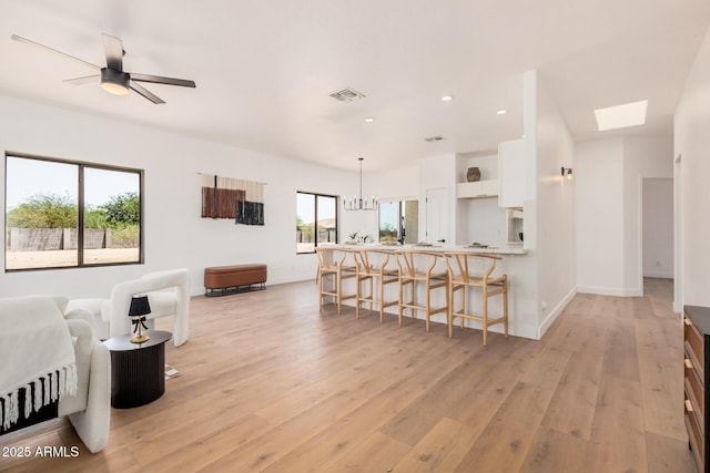 4561 E Red Bird Ln, San Tan Valley, AZ 85140 - living room featuring light wood finished floors, a skylight, and recessed lighting