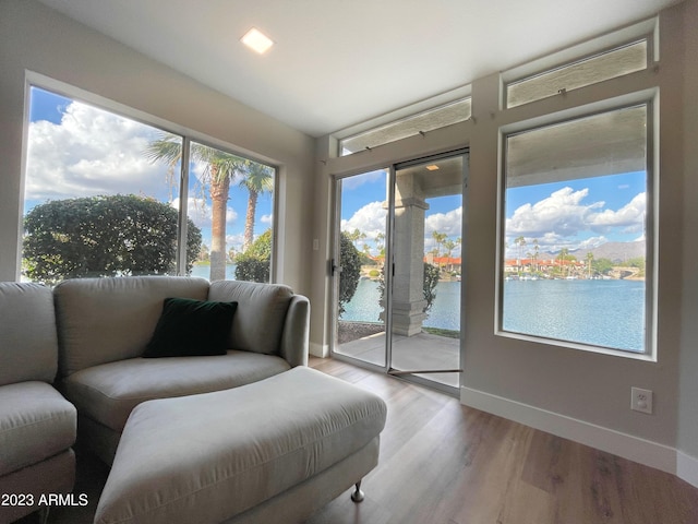 interior space featuring a wealth of natural light, a water view, and light wood-type flooring