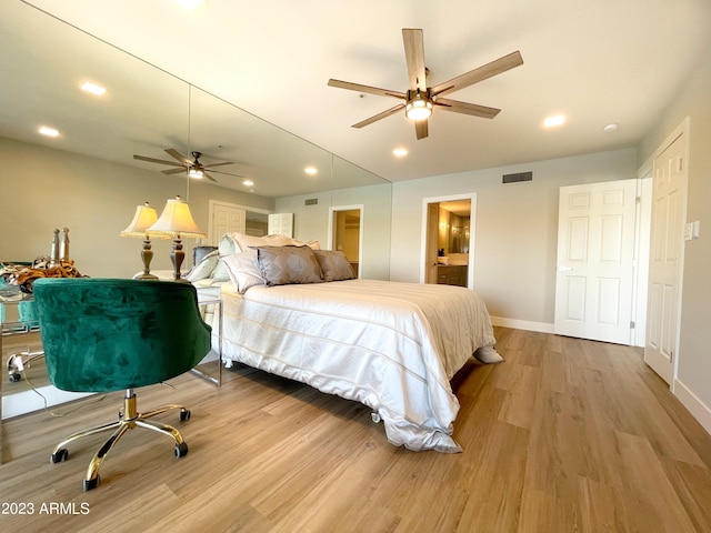 bedroom featuring light hardwood / wood-style floors, ensuite bath, and ceiling fan