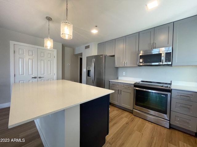 kitchen with gray cabinetry, a kitchen island, and stainless steel appliances