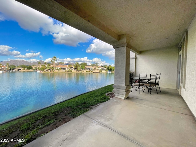 view of patio / terrace with a water and mountain view