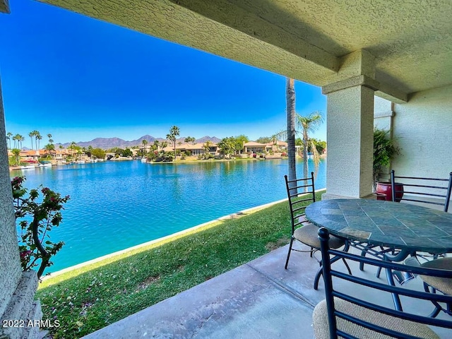 view of patio / terrace with a water and mountain view