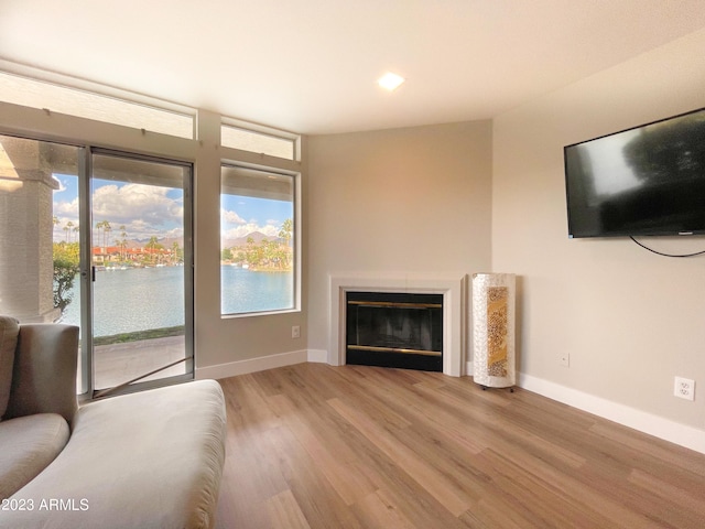 unfurnished living room with a water view and hardwood / wood-style flooring