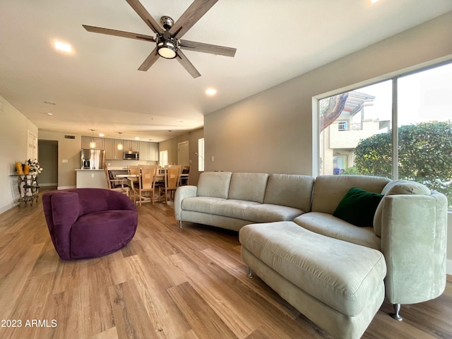 living room with light wood-type flooring and ceiling fan