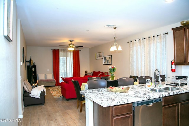 kitchen featuring pendant lighting, dishwasher, sink, light hardwood / wood-style flooring, and dark brown cabinetry