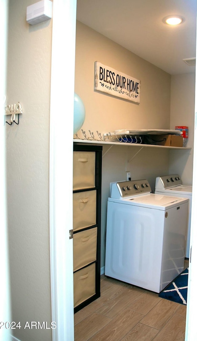 laundry area featuring light wood-type flooring and separate washer and dryer