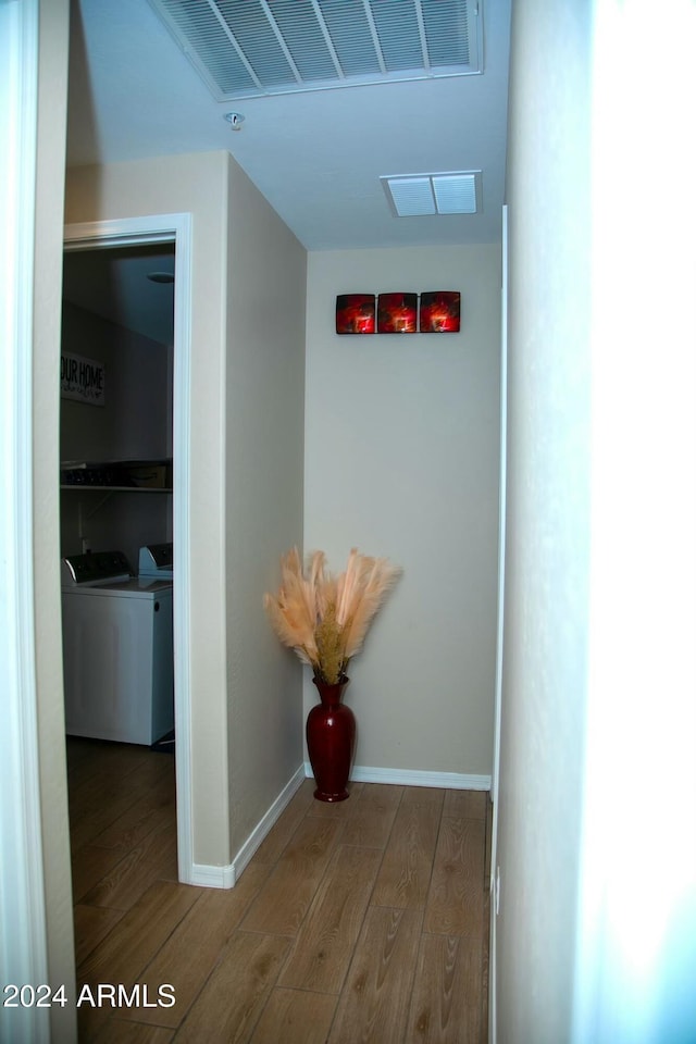 hallway with washer and clothes dryer and wood-type flooring