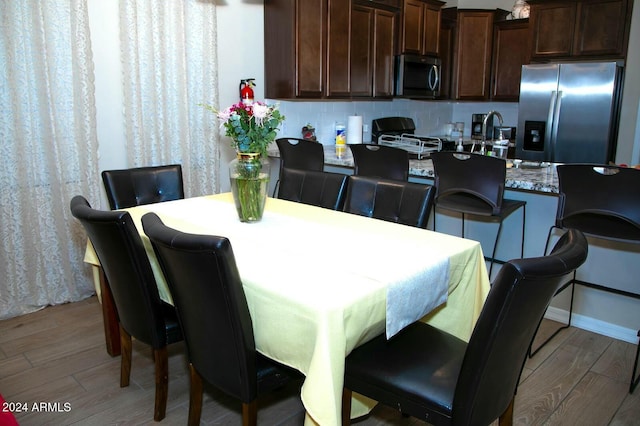 dining area with sink and light wood-type flooring