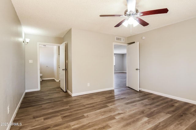 unfurnished bedroom with baseboards, wood finished floors, visible vents, and a ceiling fan