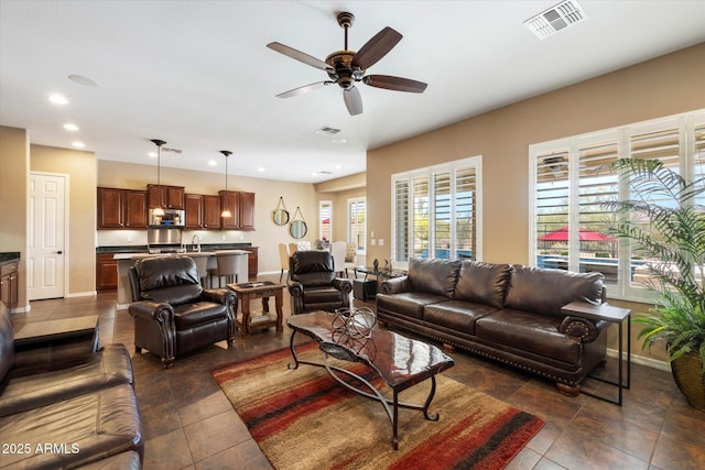 living area featuring recessed lighting, ceiling fan, visible vents, and baseboards