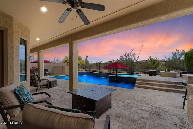 patio terrace at dusk with ceiling fan, an outdoor living space, a hot tub, a fenced in pool, and a fenced backyard