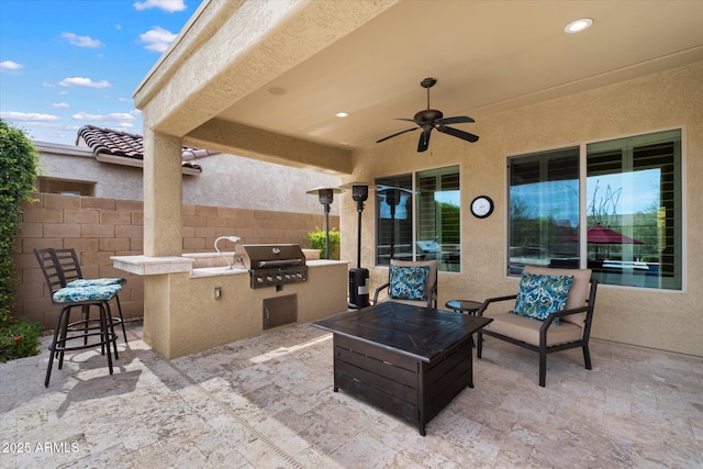 view of patio / terrace with ceiling fan, exterior kitchen, fence, and area for grilling