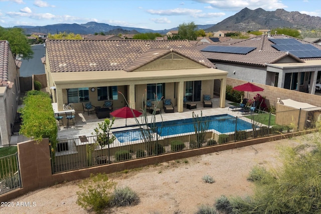 back of house featuring a fenced backyard, a patio area, a mountain view, and an outdoor hangout area